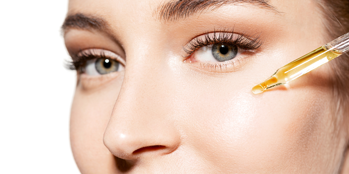 girl applying face oil on her cheeks