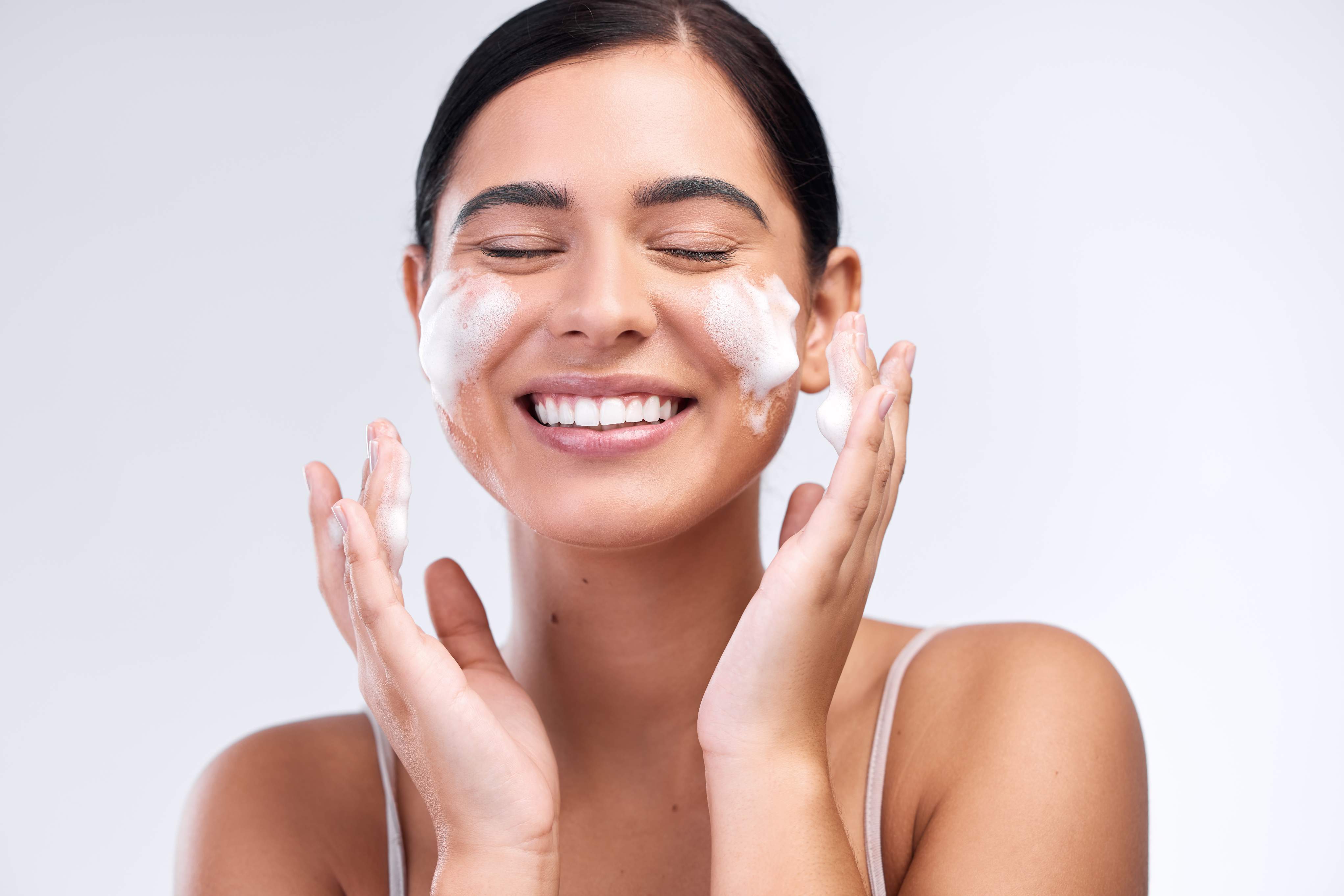 girl smiling while washing her face